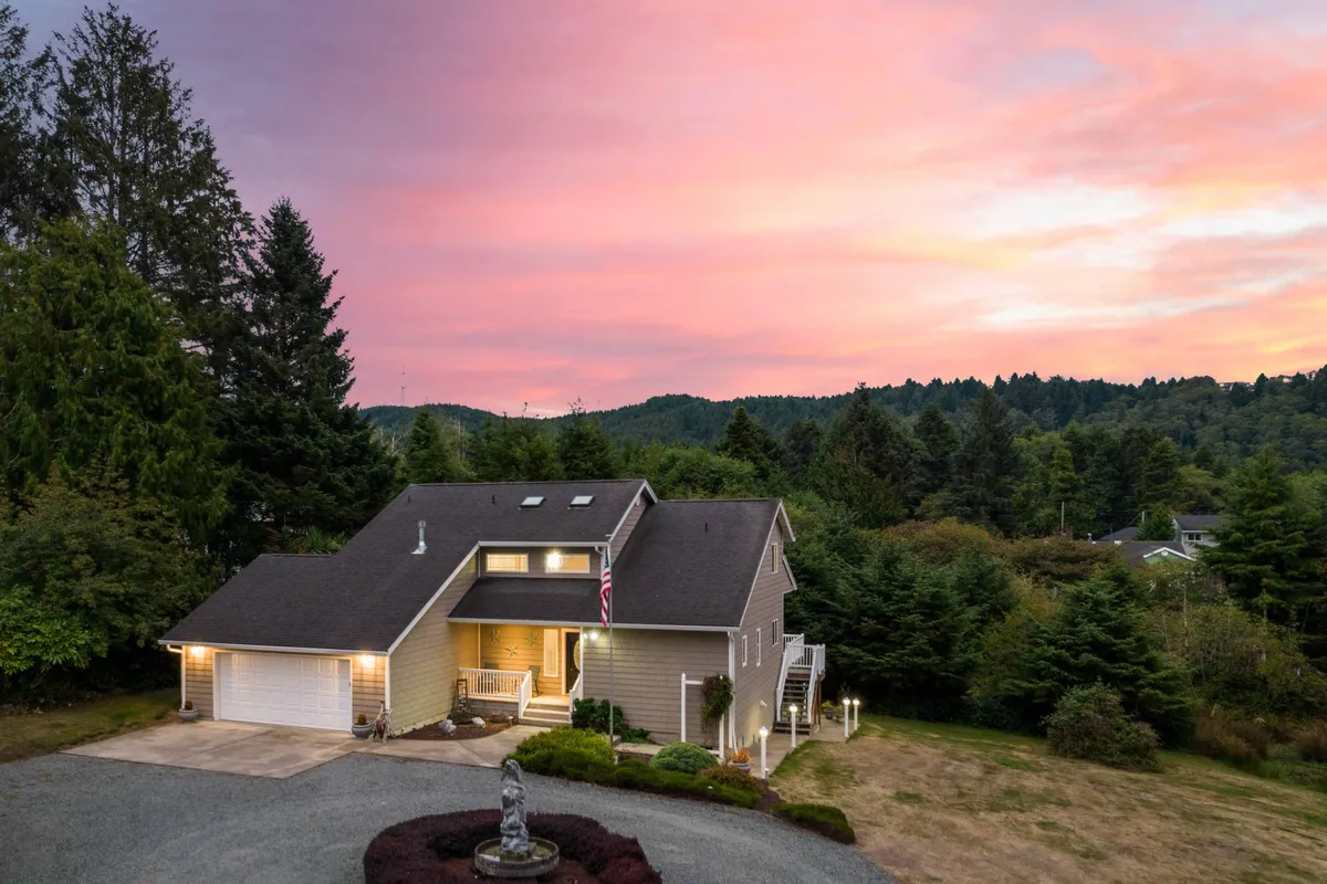 This exterior image showcases the main house, a welcoming front porch, a thoughtfully landscaped yard, and a distinctive statue near the driveway. The porch area looks perfect for relaxing or informal gatherings, while the overall setting conveys a peaceful, inviting environment ideal for group retreats.