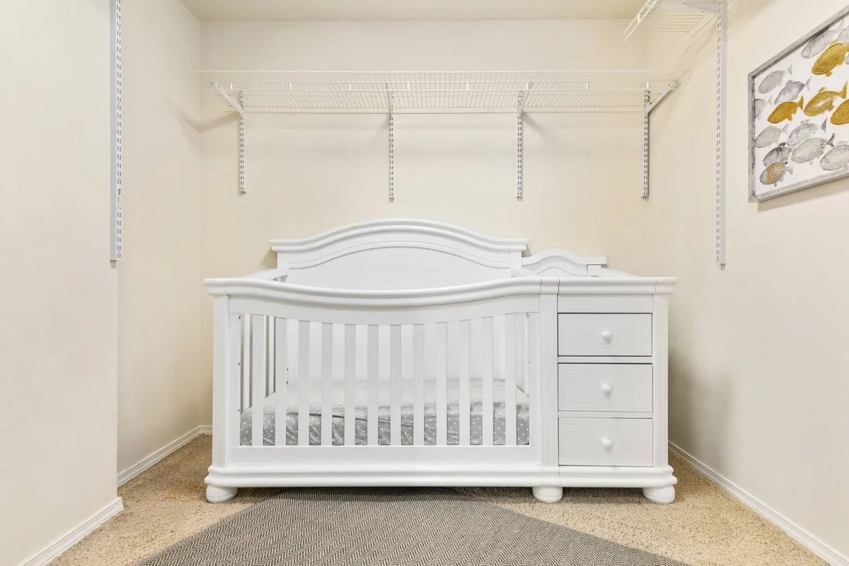 A dedicated nursery area with a crib, storage drawers, and cheerful wall art. The space is designed for families with young children, ensuring that even the littlest guests have their own restful retreat.