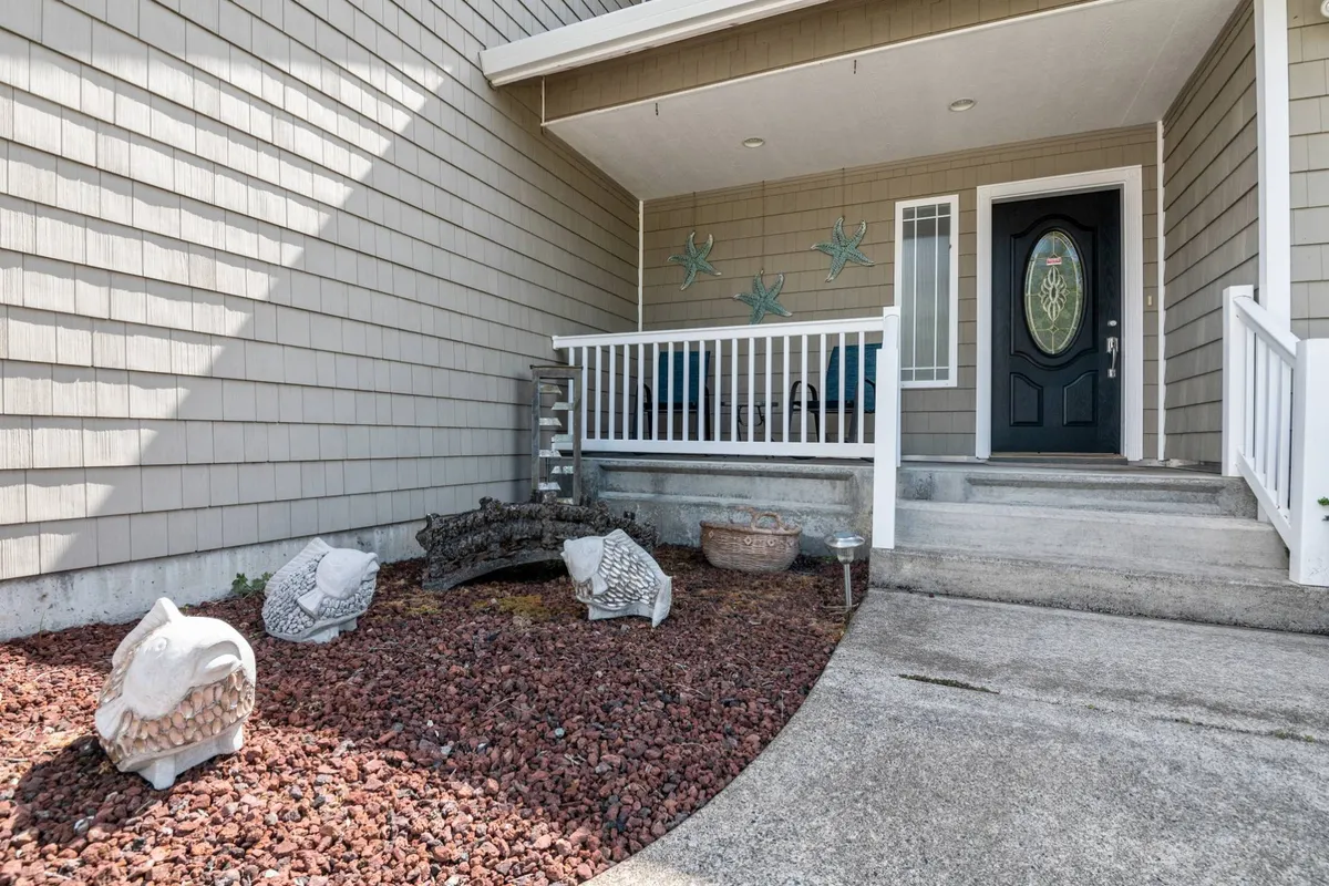 A cozy porch seating area decorated with fish-themed sculptures and starfish wall décor, offering a friendly ambiance for outdoor conversations or solo relaxation. The intimate setting underlines the porch as a retreat for both sunrise moments and summer barbecues.
